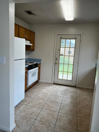 a view of kitchen with stainless steel appliances granite countertop a sink and a refrigerator