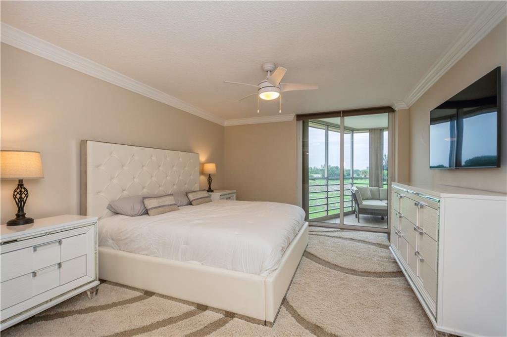 6000 Northwest 2nd Avenue, Unit 437 Boca Raton, FL 33487 - Photo 13 of 22 a bedroom with a large bed and a flat tv screen on dresser