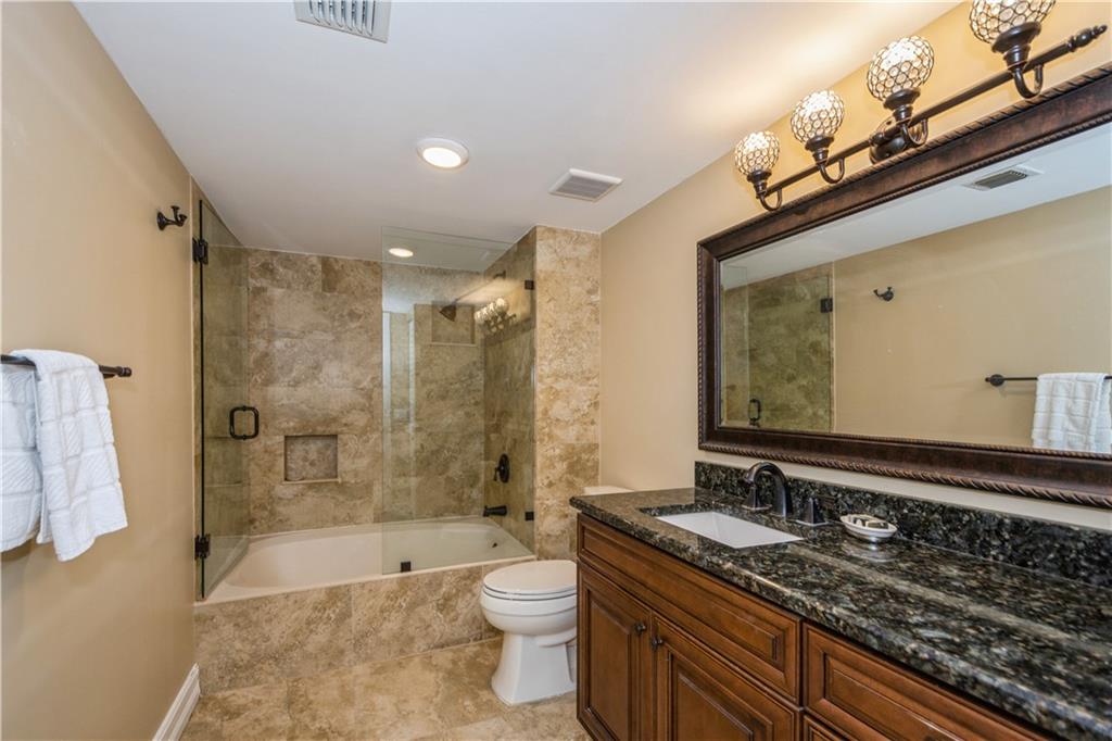 6000 Northwest 2nd Avenue, Unit 437 Boca Raton, FL 33487 - Photo 15 of 22 a bathroom with a granite countertop double vanity sink a toilet a mirror and bathtub