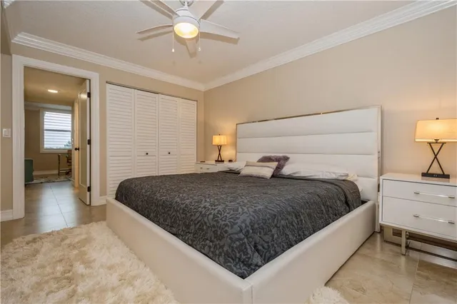 a bedroom with a large bed and ceiling fan