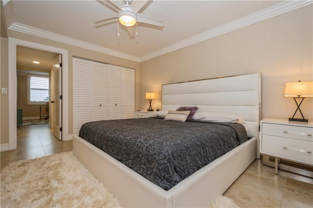 6000 Northwest 2nd Avenue, Unit 437 Boca Raton, FL 33487 - Photo 17 of 22 a bedroom with a large bed and ceiling fan