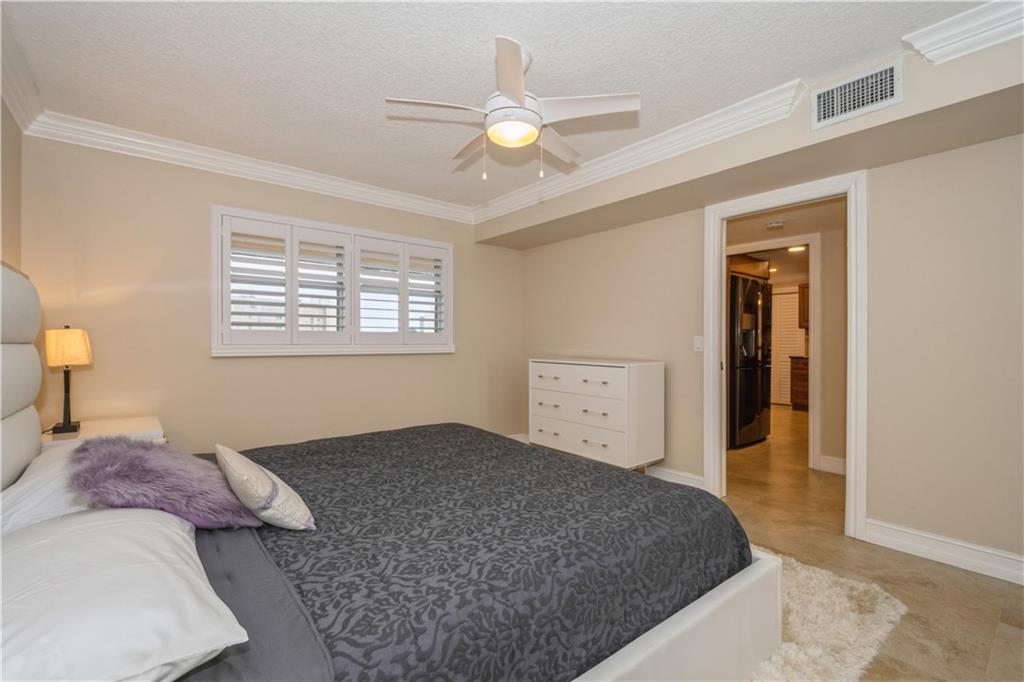 6000 Northwest 2nd Avenue, Unit 437 Boca Raton, FL 33487 - Photo 18 of 22 a bedroom with a large bed and a chandelier