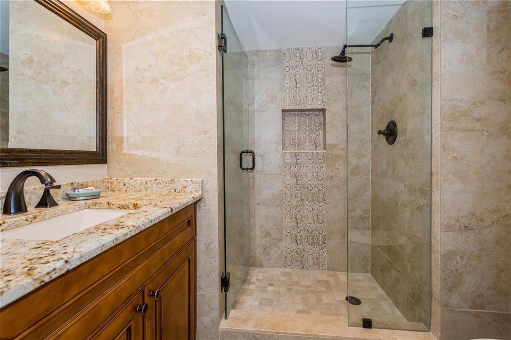 6000 Northwest 2nd Avenue, Unit 437 Boca Raton, FL 33487 - Photo 19 of 22 a bathroom with a granite countertop sink a mirror and shower
