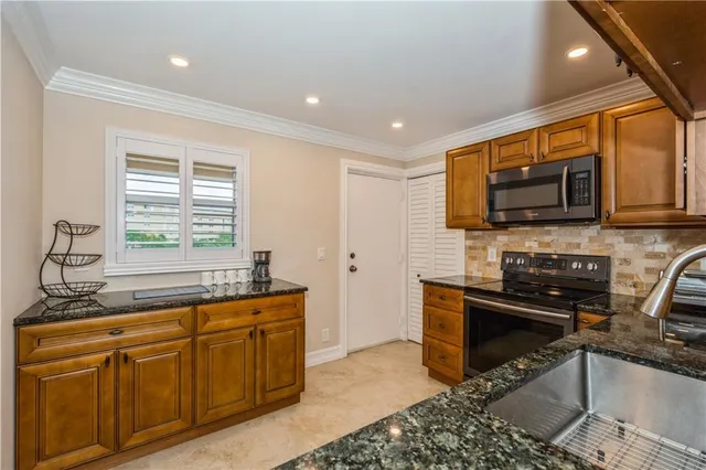 a kitchen with stainless steel appliances granite countertop a stove sink and microwave