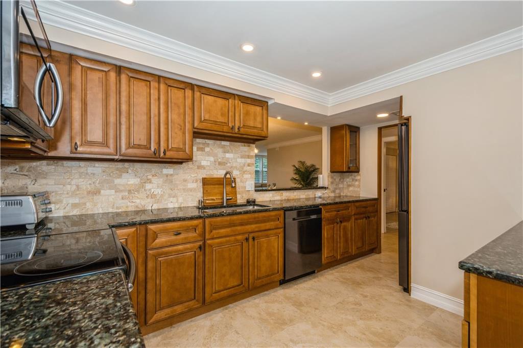 6000 Northwest 2nd Avenue, Unit 437 Boca Raton, FL 33487 - Photo 6 of 22 a kitchen with stainless steel appliances granite countertop a stove a sink and a microwave