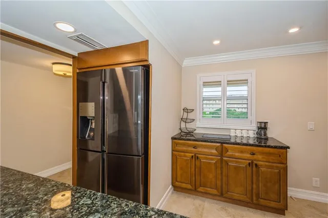 a kitchen with stainless steel appliances granite countertop a refrigerator a sink and a stove