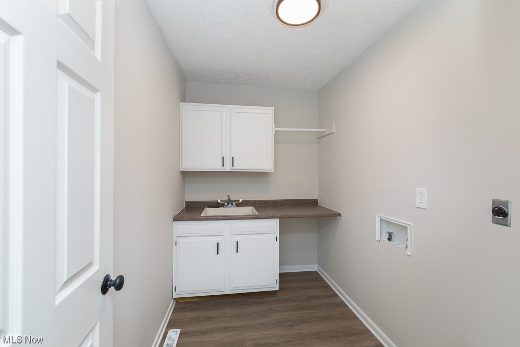 171 Granger Road, Unit 136 Medina, OH 44256 - Photo 16 of 24 Washroom featuring a textured ceiling, cabinets, dark hardwood / wood-style flooring, sink, and electric dryer hookup