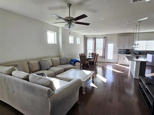 a living room with furniture wooden floor and a window