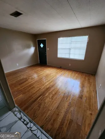 a view of a hallway with wooden floor and entryway