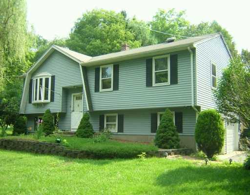 a front view of a house with a yard and trees