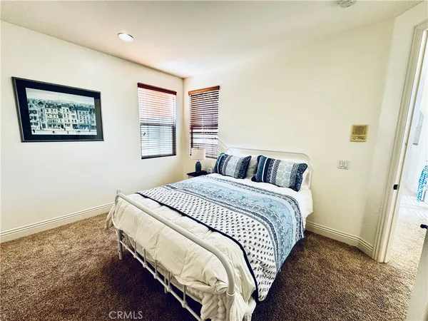 a bedroom with a bed and a lamp on dresser