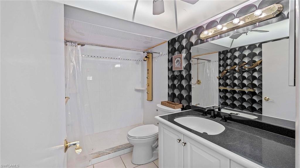 601 Seaview Court, Unit C106 Marco Island, FL 34145 - Photo 16 of 42 Bathroom featuring vanity, a shower stall, light tile patterned floors, and a ceiling fan