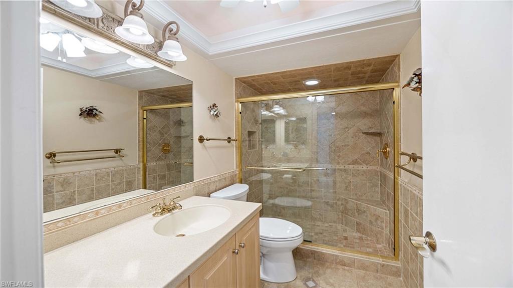 601 Seaview Court, Unit C106 Marco Island, FL 34145 - Photo 19 of 42 Full bath featuring vanity, a shower stall, ornamental molding, tile walls, and light tile patterned floors