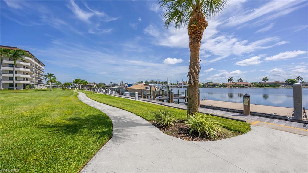 601 Seaview Court, Unit C106 Marco Island, FL 34145 - Photo 28 of 42 Surrounding community featuring a dock, a lawn, and a water view