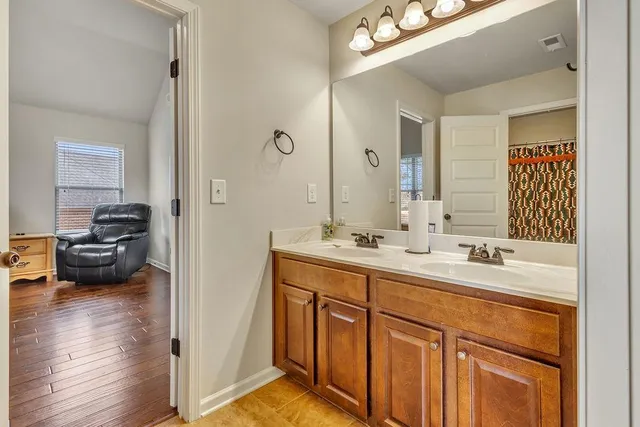 a spacious bedroom with a bed and wooden floor
