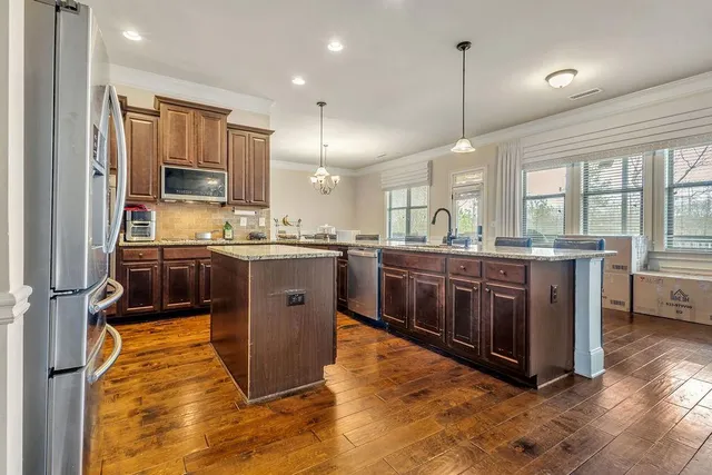 a view of a dining room and livingroom with furniture wooden floor a chandelier
