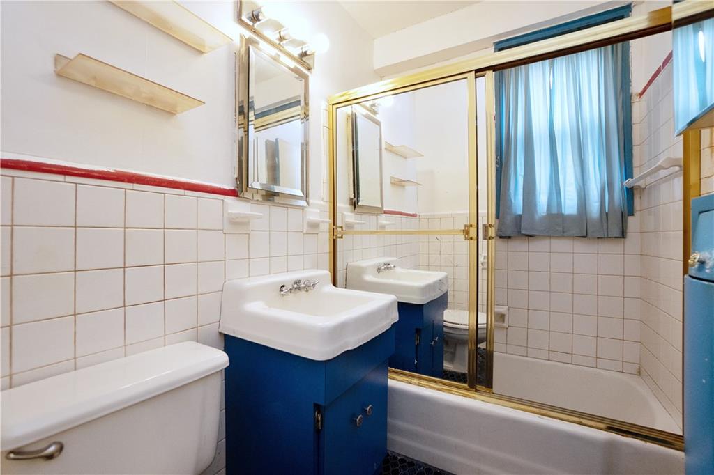 2483 West 16th Street, Unit 7H Brooklyn, NY 11214 - Photo 22 of 24 a bathroom with a sink a toilet and shower