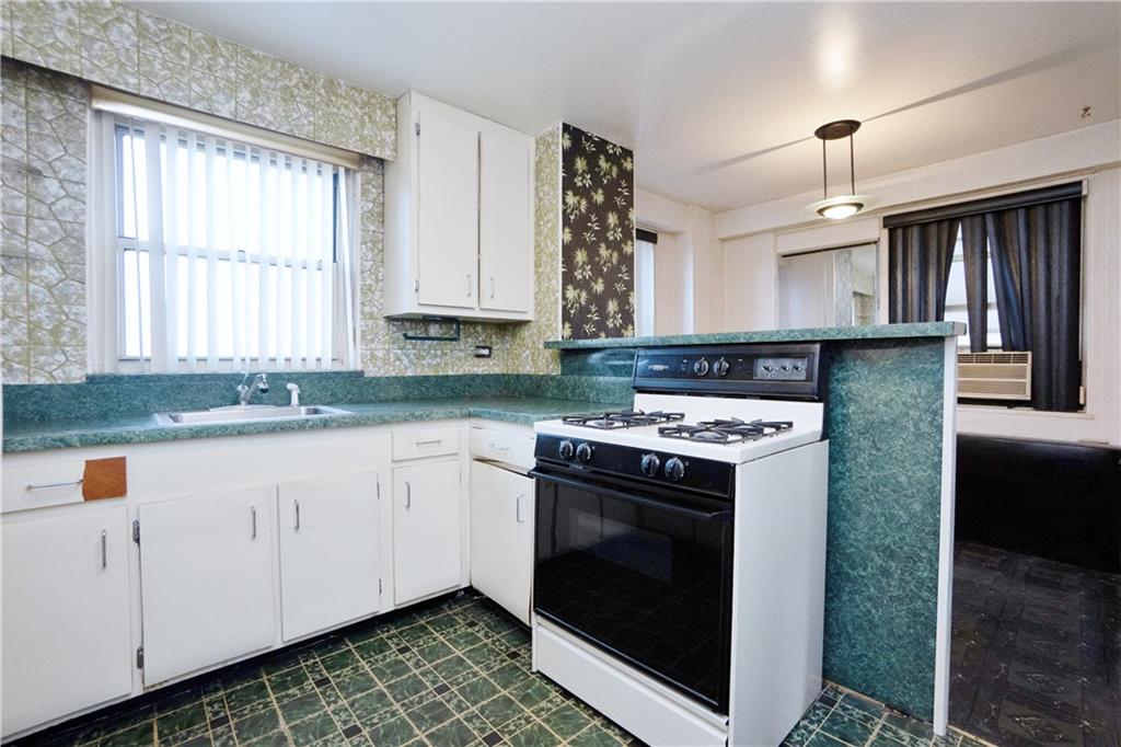2483 West 16th Street, Unit 7H Brooklyn, NY 11214 - Photo 4 of 24 a kitchen with stainless steel appliances granite countertop a stove a sink and a microwave
