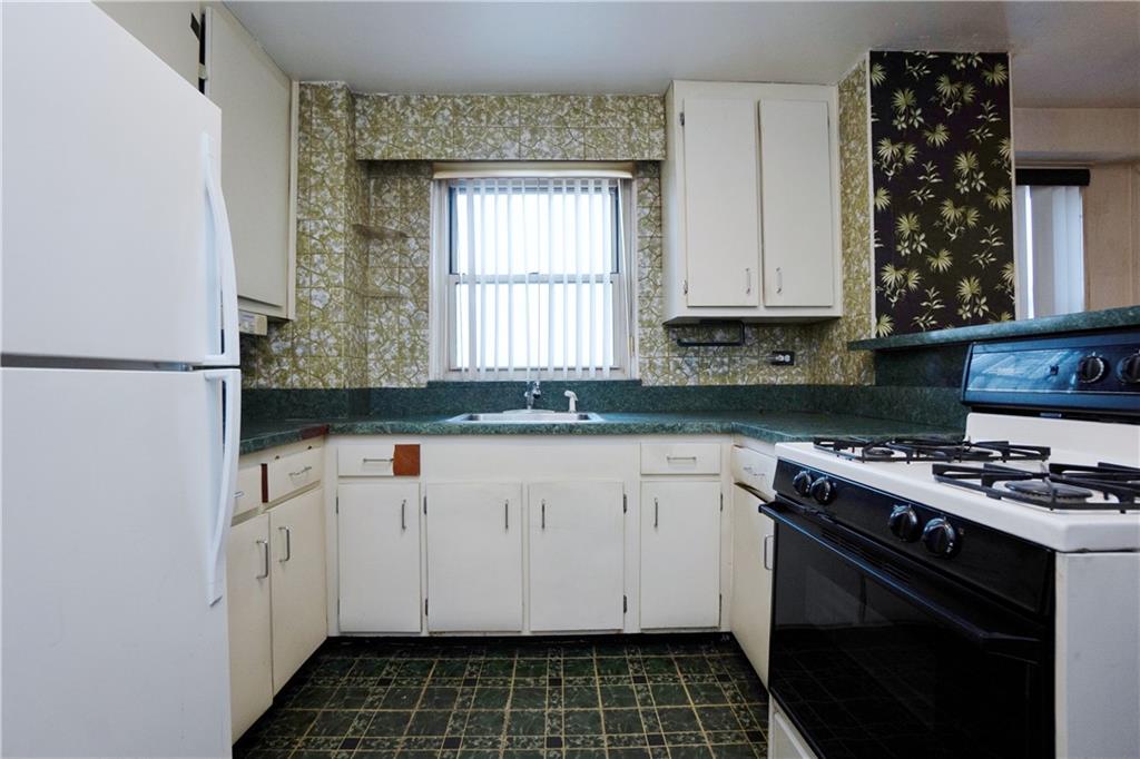 2483 West 16th Street, Unit 7H Brooklyn, NY 11214 - Photo 5 of 24 a kitchen with a stove a sink and a white wooden cabinets