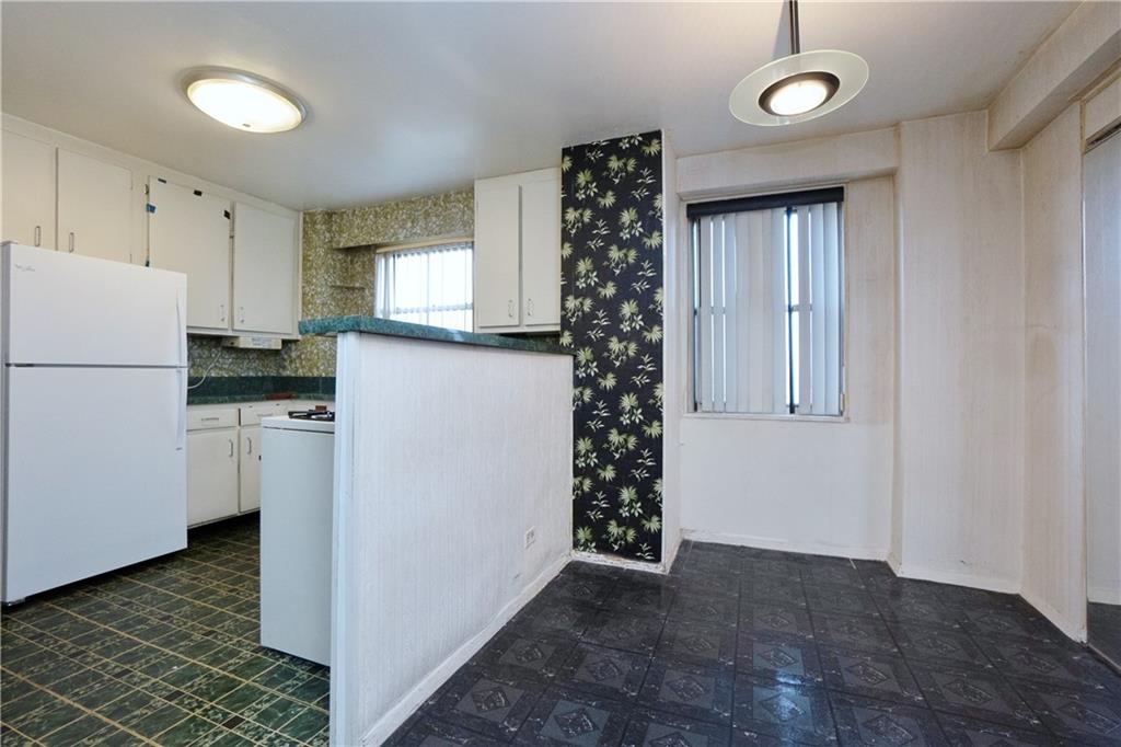 2483 West 16th Street, Unit 7H Brooklyn, NY 11214 - Photo 7 of 24 a kitchen with a refrigerator a stove top oven and a window