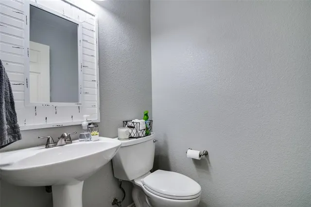 a bathroom with a sink mirror and toilet