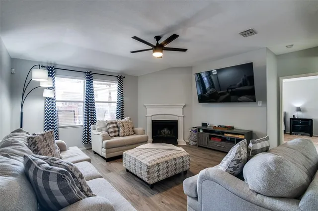 a living room with furniture a flat screen tv and a fireplace