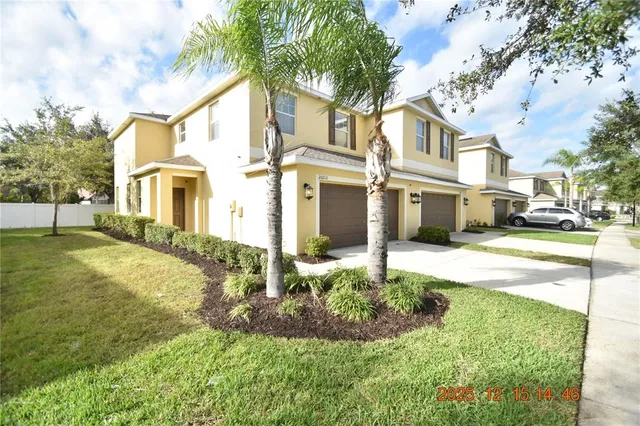 a view of a white house with a big yard and large trees