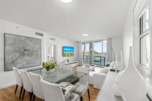 a dining room with furniture a flat screen tv and a floor to ceiling window