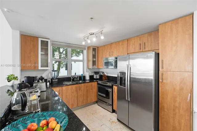 a kitchen with stainless steel appliances granite countertop a sink stove and refrigerator