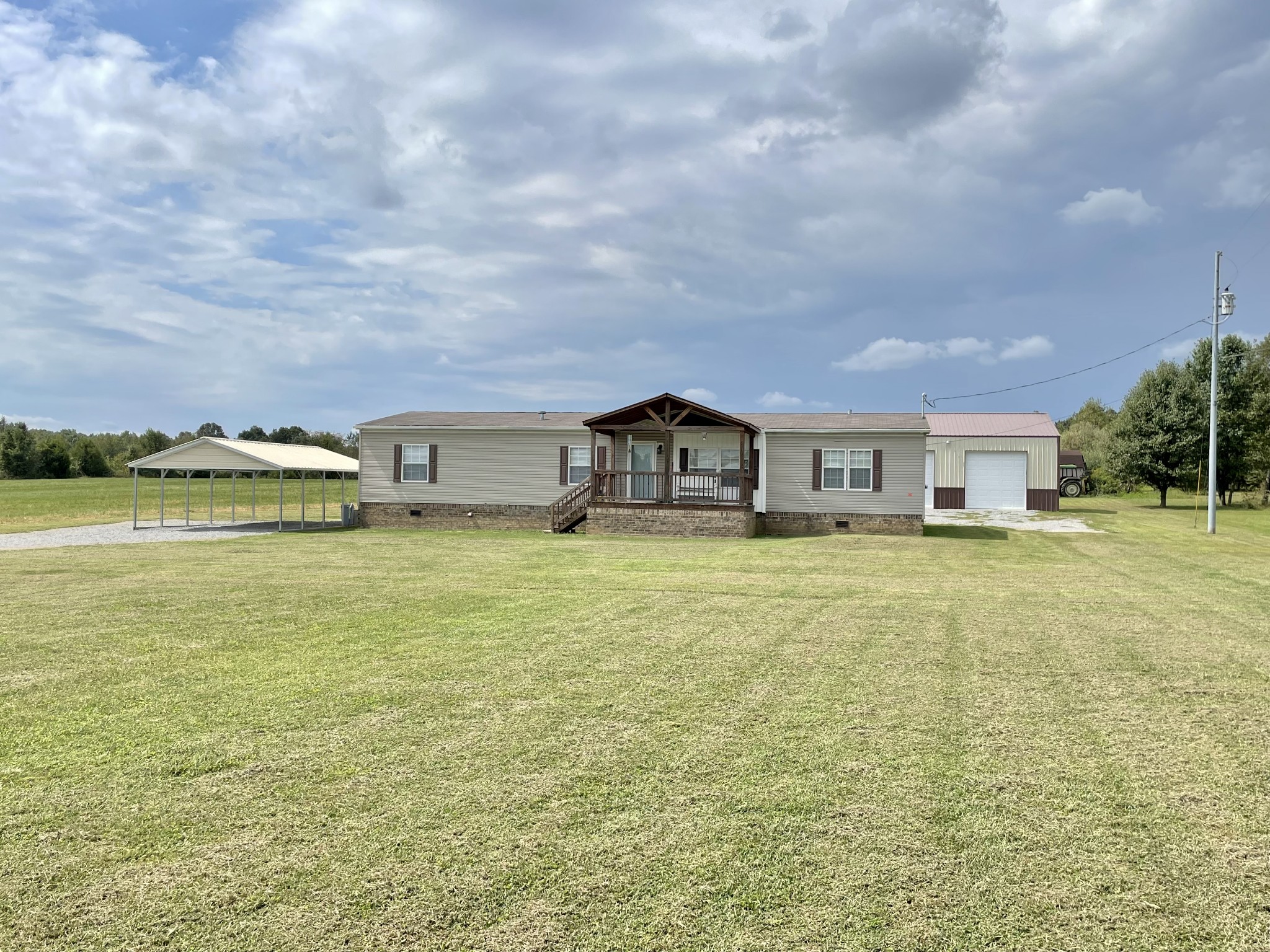 a front view of a house with a garden and lake view