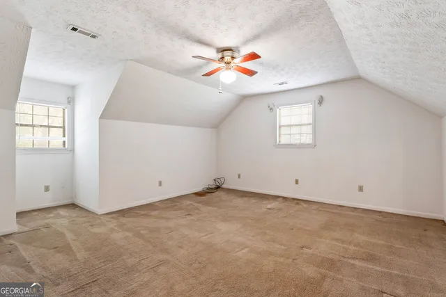 an empty room with windows and ceiling fan view
