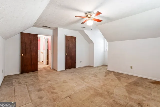a view of an empty room with a chandelier fan