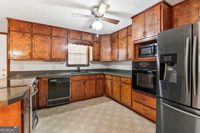 a kitchen with stainless steel appliances granite countertop a refrigerator and a stove top oven