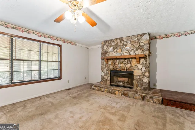 a view of an empty room with a fireplace and a window