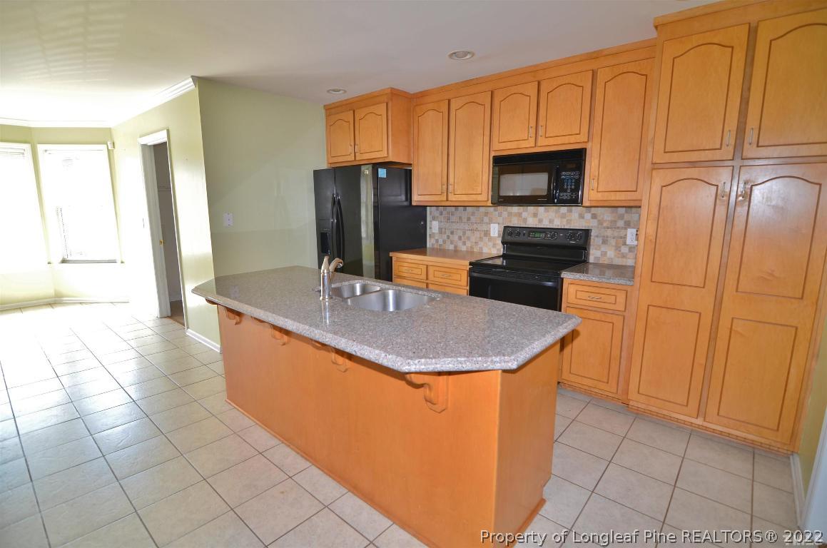 75 Natalie Drive Raleigh, NC 27603 - Photo 12 of 24 a kitchen with stainless steel appliances granite countertop a sink a microwave counter space and cabinets