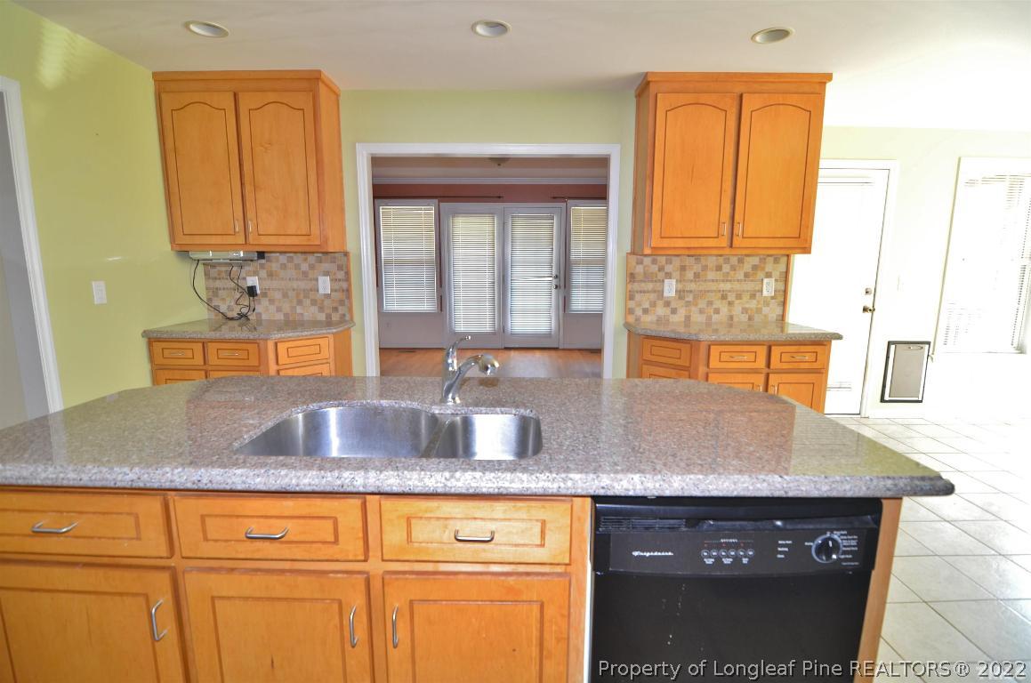 75 Natalie Drive Raleigh, NC 27603 - Photo 14 of 24 a kitchen with granite countertop a sink a stove and cabinets
