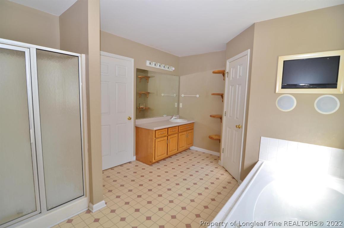 75 Natalie Drive Raleigh, NC 27603 - Photo 21 of 24 a bathroom with a sink a toilet a mirror and shower