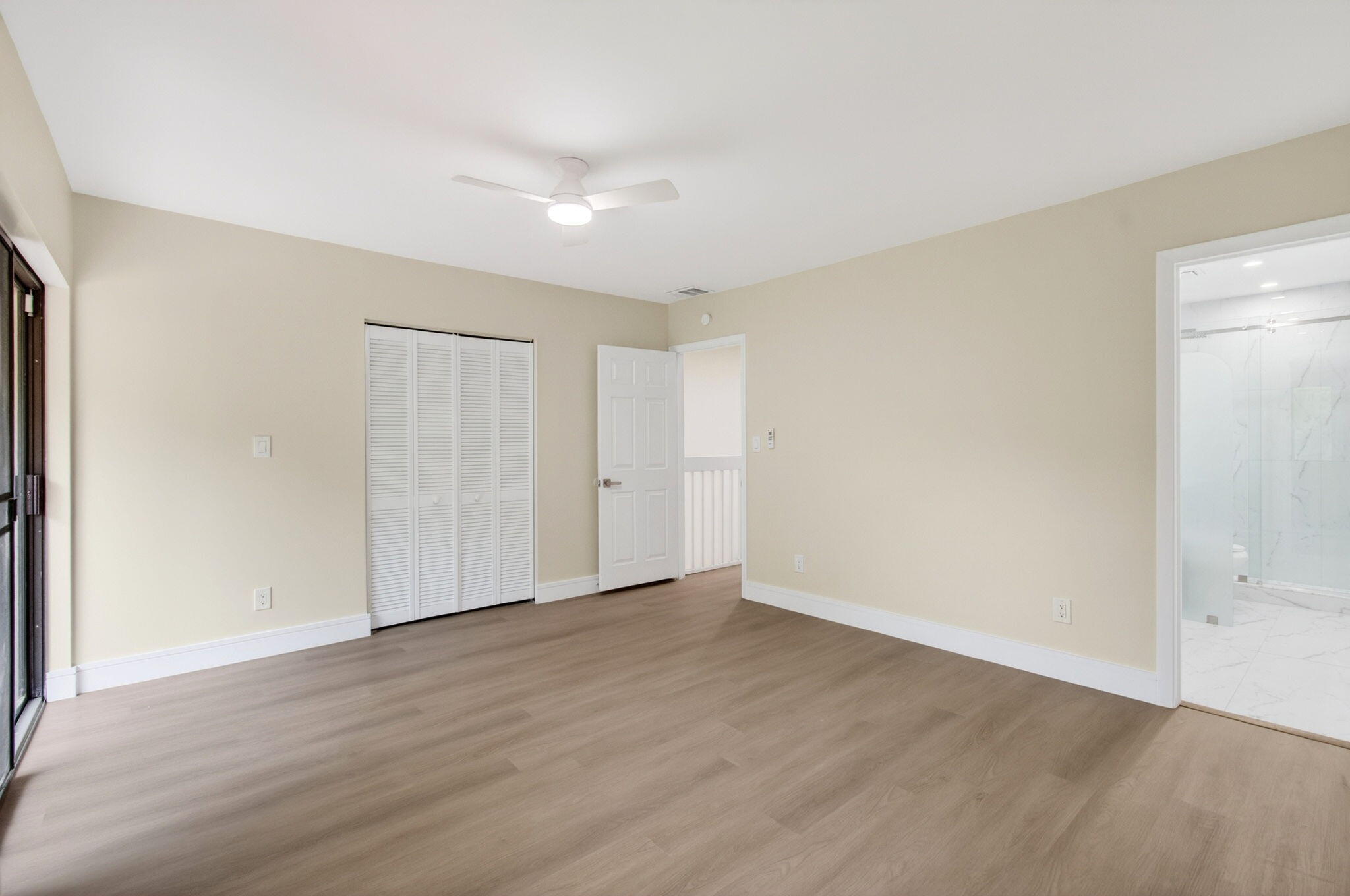 1330 Northwest 13th Street, Unit 12 Boca Raton, FL 33486 - Photo 24 of 52 a view of an empty room with wooden floor and a window