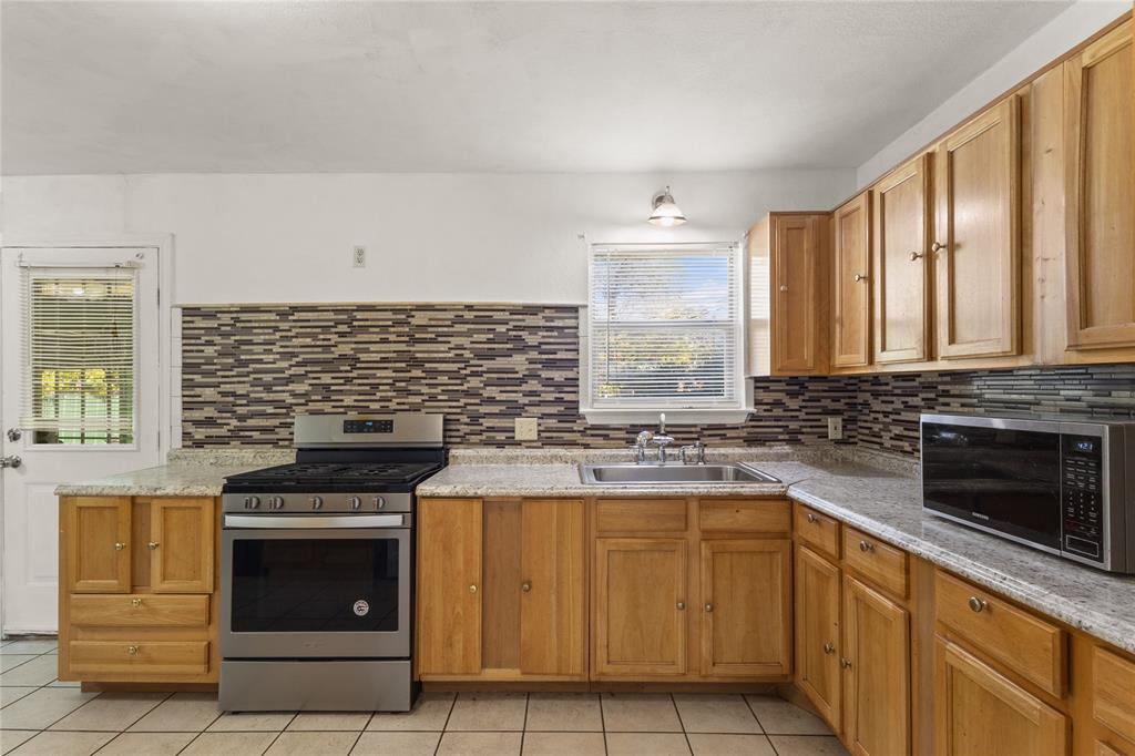4805 Ira Street Haltom City, TX 76117 - Photo 7 of 16 a kitchen with a stove and a sink