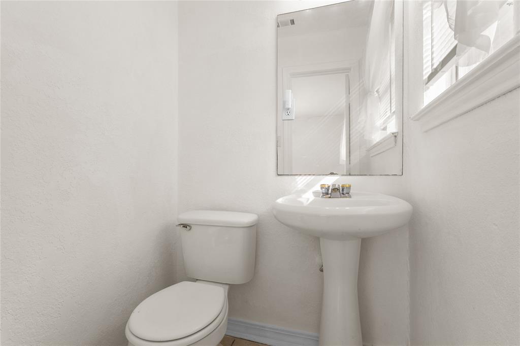 4805 Ira Street Haltom City, TX 76117 - Photo 10 of 16 a bathroom with a sink a toilet and mirror