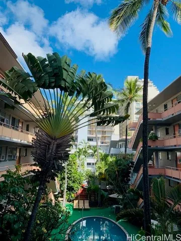 a view of a house with a yard and potted plants