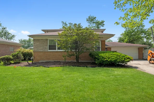 a view of a house with a yard and a garden