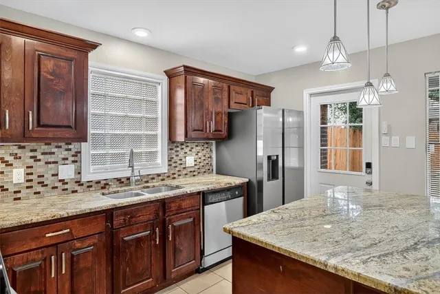 a kitchen with stainless steel appliances granite countertop a sink refrigerator and cabinets