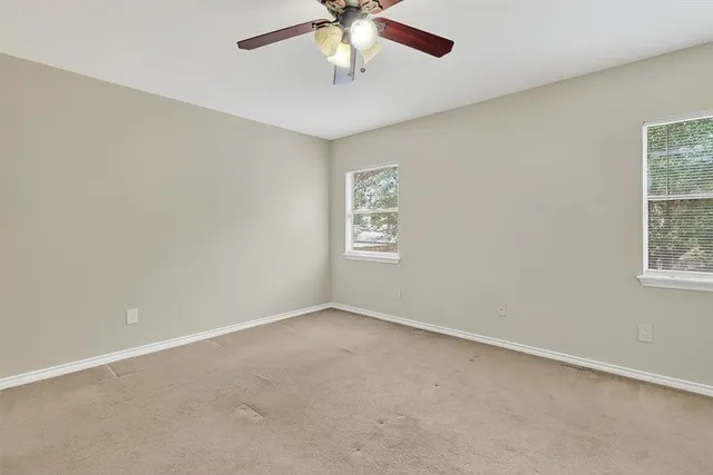an empty room with a window and a fan