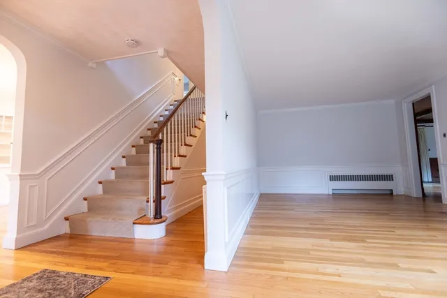 a view of entryway and hall with wooden floor