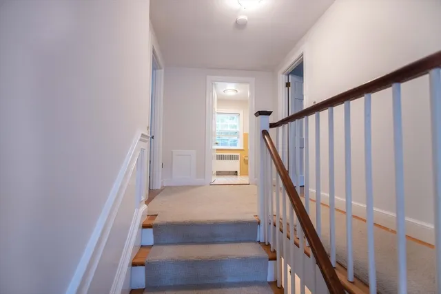 a view of staircase with wooden floor and white walls