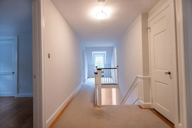 a view of a hallway with wooden floor and staircase
