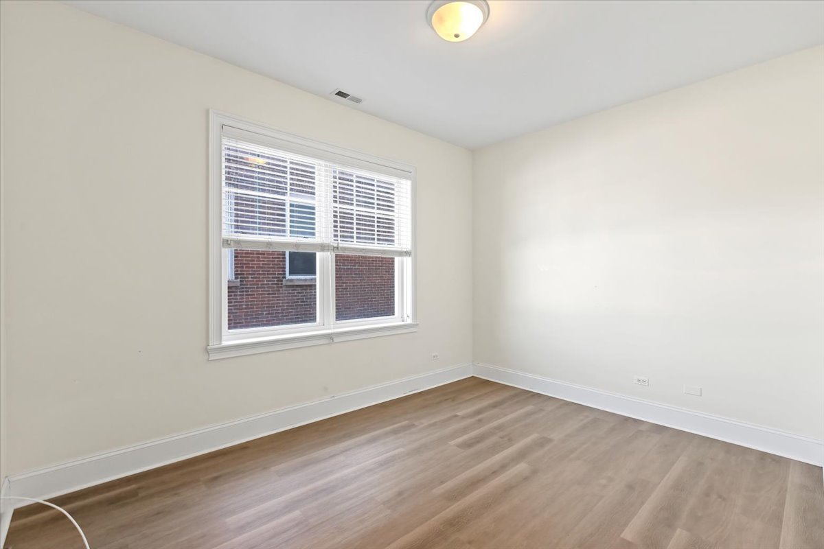 2500 Green Bay Road, Unit 202 Evanston, IL 60201 - Photo 7 of 10 an empty room with wooden floor and windows