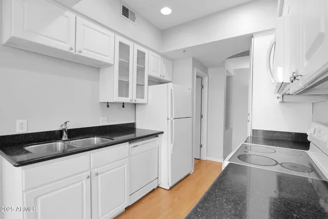 a kitchen with granite countertop a sink and a stove