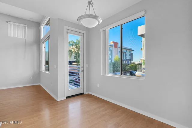 a view of an empty room with window and wooden floor